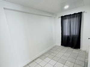 Unfurnished room with baseboards and light tile patterned flooring