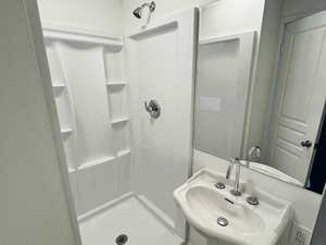 Full bathroom featuring a shower stall, light tile patterned floors, and a textured ceiling