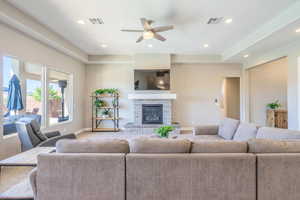 Living area featuring a ceiling fan, recessed lighting, a fireplace, and carpet floors