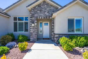 View of exterior entry with stone siding and stucco siding