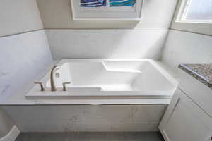 Full bathroom featuring vanity and a garden tub