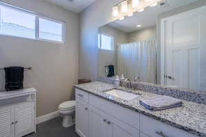 Bathroom featuring vanity, dark tile patterned floors, and a shower with shower curtain