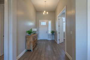 Foyer entrance featuring dark wood-style flooring and a chandelier