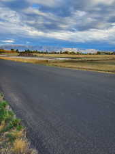 View of asphalt street featuring a mountain view and a view of rural / pastoral area