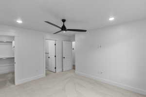 Unfurnished bedroom with a spacious closet, light colored carpet, recessed lighting, and a ceiling fan
