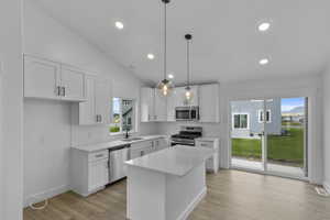 Kitchen featuring decorative light fixtures, stainless steel appliances, white cabinets, light wood-type flooring, and recessed lighting