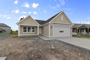 Craftsman inspired home with concrete driveway, an attached garage, and board and batten siding