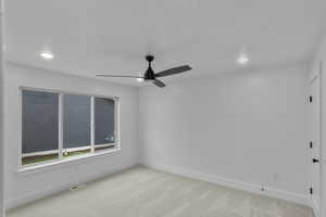 Empty room with light colored carpet, ceiling fan, and recessed lighting