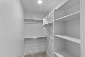 Walk in closet featuring light colored carpet