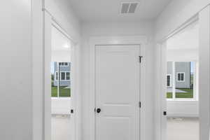 Corridor with light carpet and healthy amount of natural light