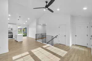 Additional living space featuring light wood-type flooring, recessed lighting, high vaulted ceiling, and ceiling fan