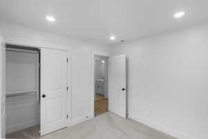 Unfurnished bedroom featuring light colored carpet, a closet, and recessed lighting