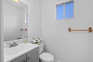 Half bathroom with vanity and toilet