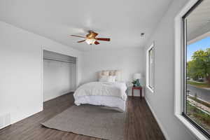 Bedroom with dark wood finished floors, a ceiling fan, and a closet