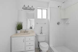 Full bath featuring vanity, a shower stall, and light tile patterned flooring