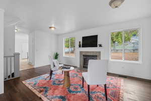 Living area featuring a textured ceiling, wood finished floors, and a fireplace