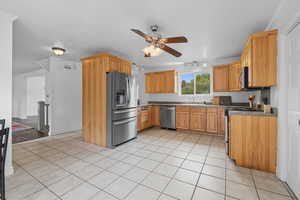 Kitchen featuring light tile patterned floors, stainless steel appliances, a ceiling fan, and track lighting