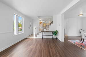 Living room with a textured ceiling, wood finished floors, stairway, and crown molding