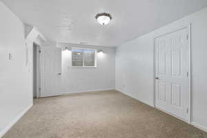 Spare room featuring light carpet and a textured ceiling