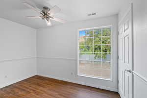 Unfurnished room featuring dark wood finished floors and a ceiling fan