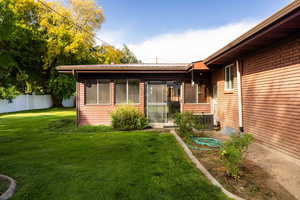 Rear view of house with a metal roof, a family room, and brick siding