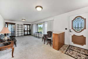 Entryway with plenty of natural light and light carpet