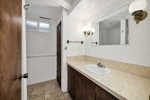 3/4 Bathroom with vanity, light tile patterned floors, and a textured ceiling
