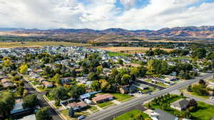 Aerial view of property's location featuring a mountain backdrop and nearby suburban area