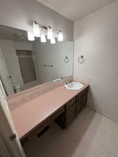 Bathroom featuring a stall shower, vanity, a textured ceiling, and a closet