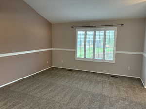 Carpeted empty room featuring baseboards
