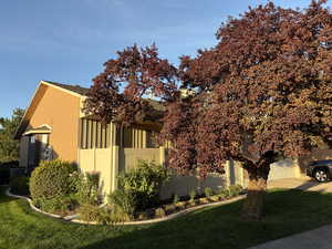 View of property exterior with a yard, a garage, and brick siding