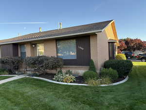View of home's exterior with a lawn and brick siding