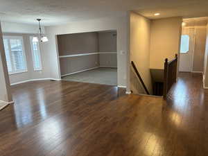 Empty room with dark wood-style flooring and a textured ceiling
