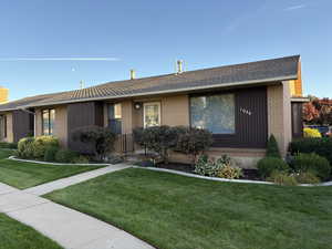 View of front of house with a front yard and brick siding