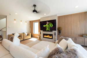 Living area featuring wood finished floors, wooden walls, recessed lighting, and a tile fireplace