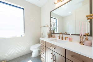Half bath with dark tile patterned flooring and vanity