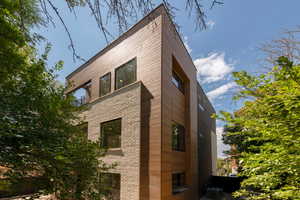 View of side of property with a central air condition unit and brick siding