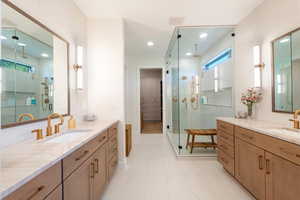 Full bathroom featuring a shower stall, two vanities, light marble finish flooring, a walk in closet, and recessed lighting