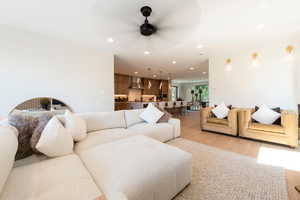 Living room with recessed lighting, wood finished floors, and a ceiling fan