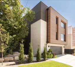 Contemporary house with driveway, an attached garage, and brick siding