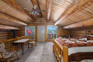 Bedroom with log walls, carpet, a wood stove, and wood ceiling