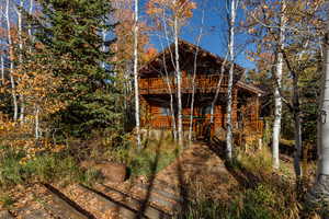 Back of property featuring log veneer siding and a deck