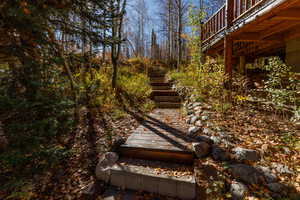 View of yard with a deck and a wooded view