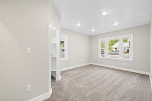 Primary bedroom with light carpet, walk-in closet and recessed lighting. _!