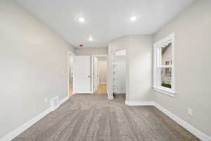 Unfurnished bedroom with carpet flooring, a spacious closet, and recessed lighting