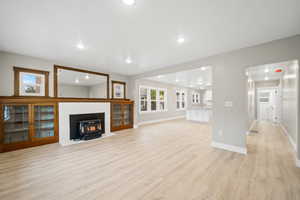 Unfurnished living room with a wood stove, light wood-style flooring, and recessed lighting