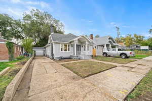 Bungalow featuring a chimney, a shingled roof, and a garage.