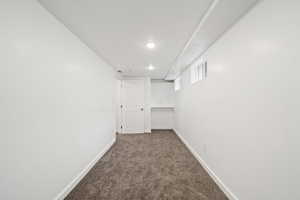 Basement Bedroom featuring dark carpet and baseboards