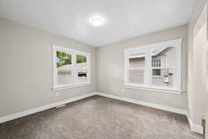 Spare room with baseboards and carpet flooring