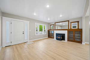 Foyer entrance featuring a wood stove, light wood-style flooring, and recessed lighting